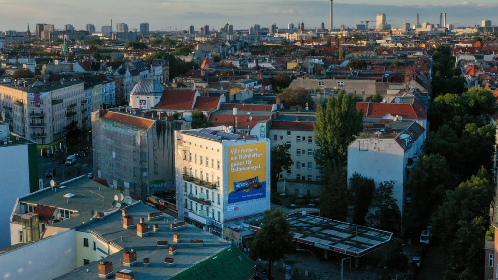 the nu company fordert ein Reinheitsgebot für Schokoriegel. Riesenposter in Berlin